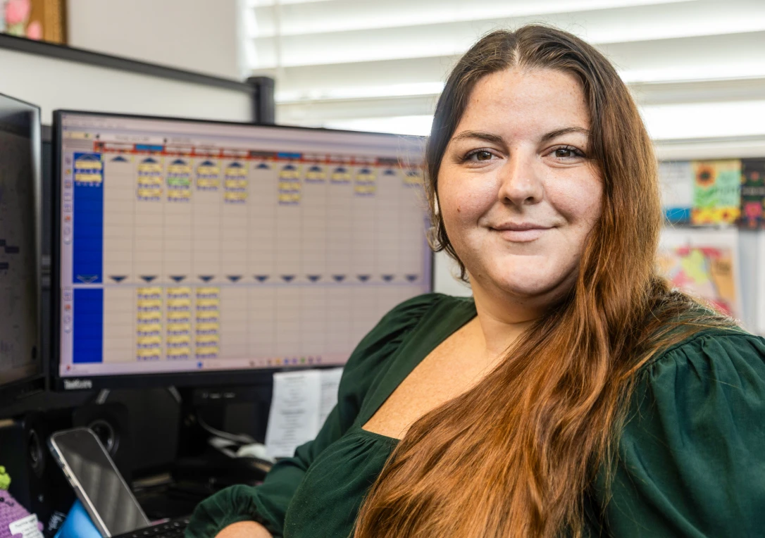 woman smiling sitting in front of computer screen