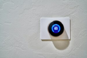 Smart thermostat installed on a white wall.