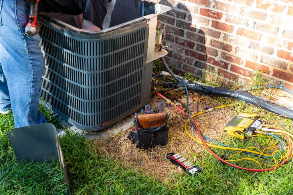 Technician completing air conditioning unit maintenance.
